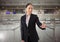 Airport businesswoman touching air in front of airport queue barriers