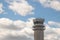 Airport control tower against a partly cloudy sky