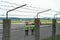 Airport employees are on the runway. The territory of the private airfield is fenced with barbed wire and a fence. The traffic