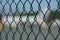 Airport fence closeup photo with blurred aircrafts