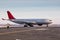 Airport marshaller meets passenger jet plane that taxiing to the parking place in a cold winter weather