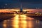 airport runway lights seen at dusk, with plane taking off