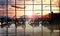 Airport terminal at sunset with passengers.