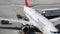 Airport worker puts luggage on baggage cart