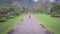 Airview of straight wild road in the middle of the jungle, motorcycle rides ahead, two people on a motorcycle, couple