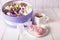 Airy and sweet handmade marshmallows on a white saucer next to a cup of tea and a box with a bouquet of marshmallow flowers