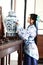 Aisan Chinese woman in traditional Blue and white Hanfu dress, stand by a ancient table.