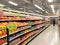 Aisle of a supermarket with gondolas shelves full of colored packages of food