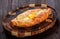 Ajarian Khachapuri traditional Georgian cheese pastry with eggs on cutting board.