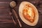 Ajarian Khachapuri traditional Georgian cheese pastry with eggs on cutting board.