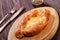 Ajarian Khachapuri traditional Georgian cheese pastry with eggs on cutting board. Homemade baking.