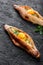 Ajarian Khachapuri traditional Georgian cheese pastry with eggs on dark wooden background.