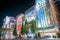 Akihabara, crowds pass below colorful signs in Akihabara. The historic electronics district has evolved into a shopping