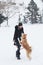 Akita dog and her owner play on snow day in the park.