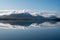 Akureyri, Iceland and surroundings reflected in calm water on sunny autumn day.