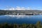 Akureyri, Iceland and surroundings reflected in calm water on sunny autumn day.