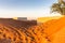 Al Madam ghost town buildings buried in sand dunes in the desert, United Arab Emirates, sunset