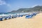 Alanya, Turkey, 05/07/2019: A large sandy beach with blue sunbeds on the seashore with strong waves