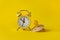 Alarm clock and baby dummy on yellow background. Time to give birth