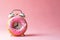 Alarm clock made of donut. Breakfast time, creative minimal concept. Fast food, sweets, sugar, diet, mealtime, break at work.