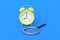 Alarm clock near magnifier on blue background