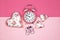 Alarm clock on pink background, baby shower concept