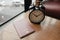 Alarm clock placed beside passport on wooden table with window a