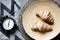 Alarm clock stands with a plate with croissants in the morning