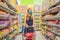 Alarmed female wears medical mask against coronavirus while grocery shopping in supermarket or store- health, safety and