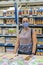Alarmed female wears medical mask against coronavirus while grocery shopping in supermarket or store- health, safety and pandemic