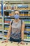 Alarmed female wears medical mask against coronavirus while grocery shopping in supermarket or store- health, safety and pandemic
