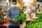 Alarmed male wears medical mask against coronavirus while grocery shopping in supermarket or store- health, safety and