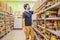 Alarmed man wears medical mask against coronavirus while grocery shopping in supermarket or store- health, safety and