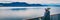 Alaska cruise travel luxury vacation woman banner panorama of inside passage scenic landscape background on balcony deck enjoying