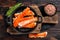 Alaskan King Crab legs Phalanx in a pan with herbs. Dark wooden background. Top view