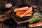 Alaskan King Crab legs Phalanx in a pan with herbs. Dark wooden background. Top view