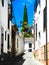 Albaicin, Old muslim quarter, district of Granada in Spain. Narrow street with white houses. Blue summer sky.