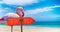 Albania flag on wooden table sign on beach background with pink flamingo. There is beach and clear water of sea and blue sky in