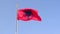 Albanian flag flies against a blue cloudless sky. Albania.