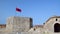 Albanian flag flies over Ali Pasha Tepelena Fortress Porto Palermo. Albania.