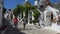 ALBEROBELLO, ITALY - JULY 31, 2017: Scenic sight with loving couple tourist enchanted by souvenir shop in Alberobello