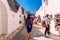 Alberobello, Italy - March 9, 2019: Tourist guide guiding a group of visitors from the beautiful city of Alberobello travel