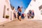 Alberobello, Italy - March 9, 2019: Tourist guide guiding a group of visitors from the beautiful city of Alberobello travel