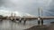 Albert Bridge over river Thames in London on gray overcast day.