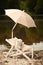 Albino ferret enjoying relaxation on beach chair with umbrella