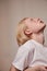 Albino man with long blonde hair looking up while posing at the studio