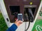 ALCALA DE HENARES, SPAIN; JANUARY 2, 2022 : MAKING A MOBILE PHONE PAYMENT AT AN ELECTRIC CAR CHARGING STATION