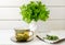 Alchemilla vulgaris, common lady\\\'s mantle medicinal herbal tea in clear cup. Fresh lady\\\'s mantle plants in vase.