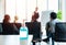 Alcohol gel bottle on table with blurred defocused group of meeting business person in background, health care personal hygiene in