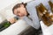 Alcoholic addict woman lying on sofa hangovered with bottles